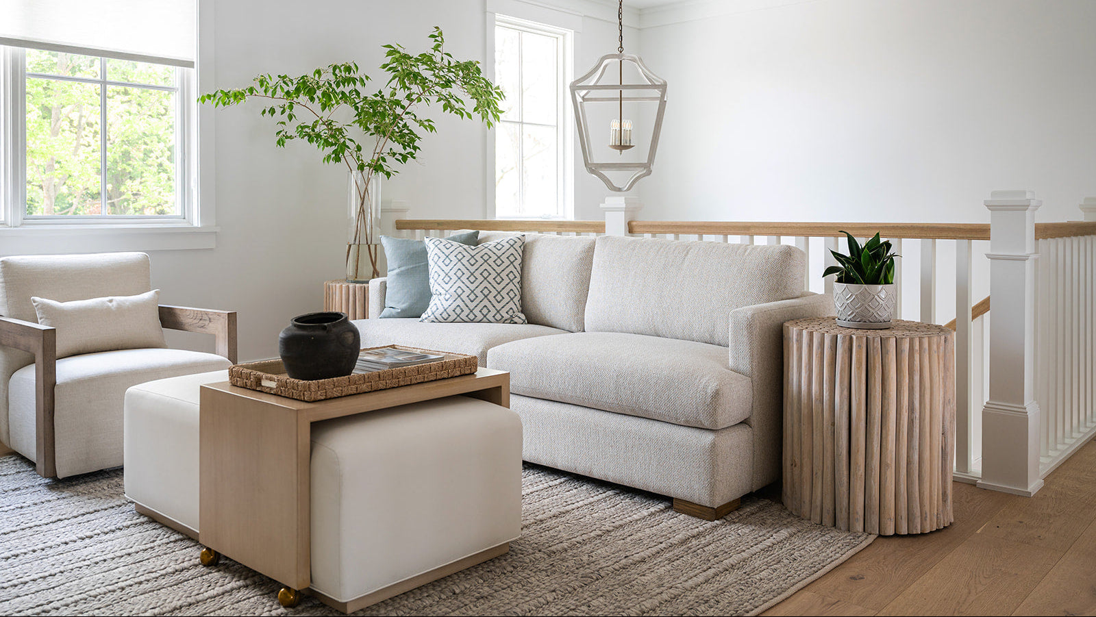 Modern living room with a white sectional sofa, armchair, and side table.